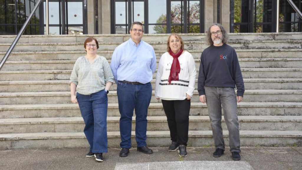 Catro persoas están de pé nun conxunto de escaleiras de cemento que conducen a unha entrada, as autoras e autores do libro. Todas miran cara á cámara, o que crea un sentido de unidade entre elas.
